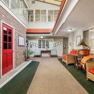 A welcoming indoor hallway with a red door, colorful seating, and decorative elements.