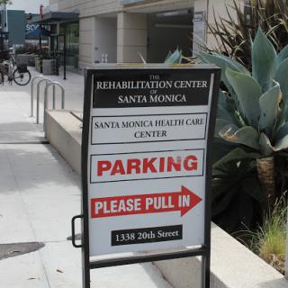 A sign indicating the location of a rehabilitation center in Santa Monica, with instructions for parking.