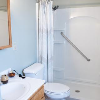 A clean and simple bathroom with a shower, toilet, and sink.