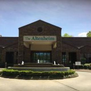 A brick building with a sign labeled 'The Altenheim' over the entrance.