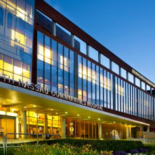 A modern glass building illuminated at dusk.