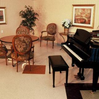 A cozy living room with a grand piano and elegant furnishings.