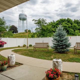 A serene backyard garden with benches and a view of a water tower.