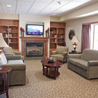 A cozy living room with comfortable seating, a fireplace, and a TV.