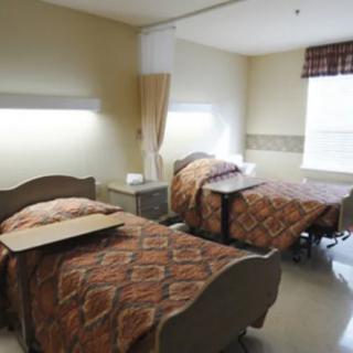A hospital room with two beds and medical equipment.