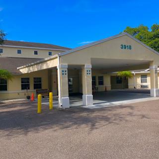 A sunny day view of a building entrance with a driveway.
