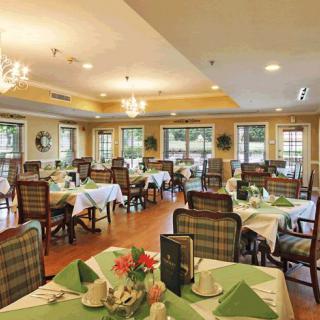 A well-lit dining area with elegantly set tables and chairs, featuring a warm and inviting atmosphere.