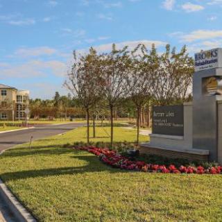 Entrance to a business center with landscaped gardens and clear signage.