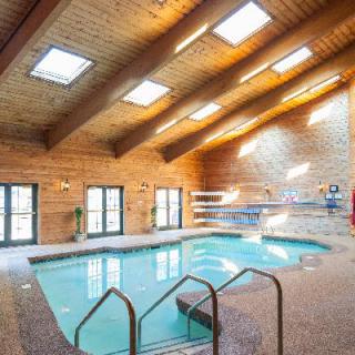 A cozy indoor swimming pool with wooden ceilings and skylights.