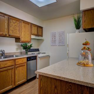 A cozy kitchen interior with wooden cabinets and modern appliances.