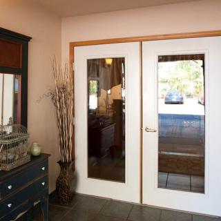 A welcoming hallway with glass-paneled doors and stylish decor.