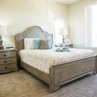 A cozy bedroom with a neatly made bed and elegant furniture.