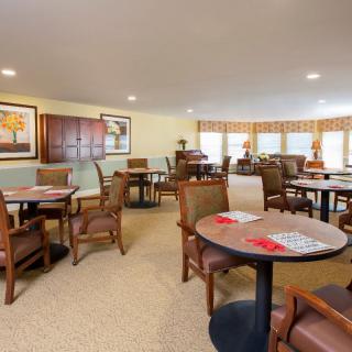 A cozy dining area featuring multiple tables and chairs with soft lighting.