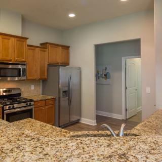 A modern kitchen with granite countertops and stainless steel appliances.