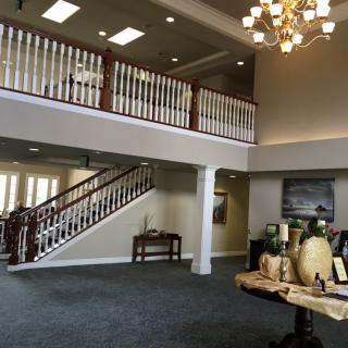 Spacious lobby with a grand staircase and elegant chandelier.