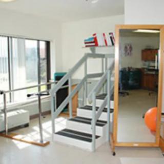 A physical therapy room with exercise equipment and a staircase for rehabilitation.
