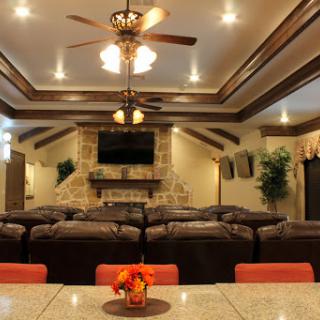 A cozy living room with comfortable seating, a stone fireplace, and warm lighting.