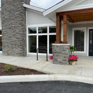A welcoming entrance featuring a mix of stone and wood elements, adorned with vibrant flowers.