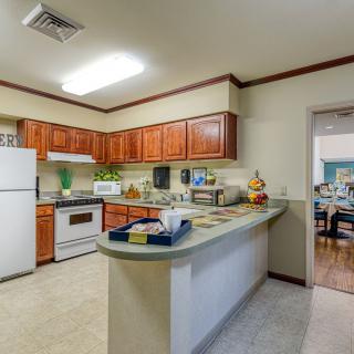 A modern kitchen with wooden cabinets and standard appliances.