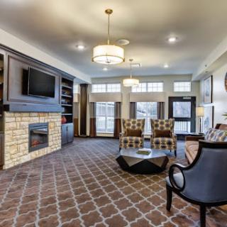 A modern living room featuring comfortable furniture, a stylish fireplace, and ample natural light.