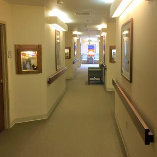 A well-lit hallway with artwork adorning the walls.
