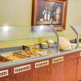 A hotel breakfast buffet with a variety of dishes displayed.