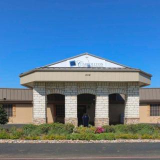 A single-story building with a prominent entrance and clear blue sky in the background.
