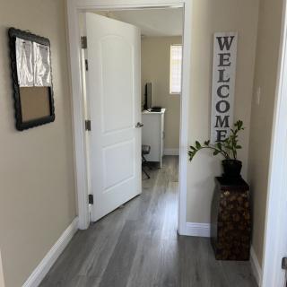 A welcoming hallway with a decorative plant and a 'Welcome' sign.