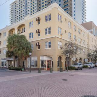 A corner view of a yellow residential building in an urban setting.