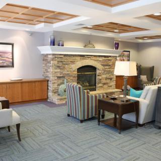 A cozy living room with a stone fireplace and comfortable seating.