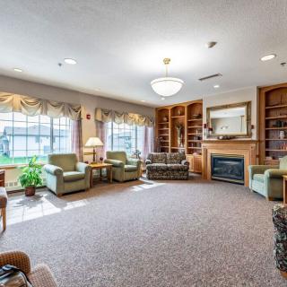 A cozy living room featuring comfortable seating, large windows, and a fireplace.