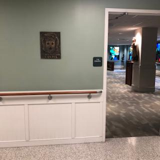 A view of a hallway with a doorway leading to another room, featuring green walls and modern furnishings.
