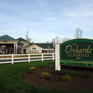 Entrance to The Orchards at Monroe community with a clubhouse and landscaped surroundings.