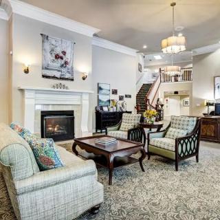 A cozy and elegant living room featuring a fireplace, plush seating, and stylish decor.