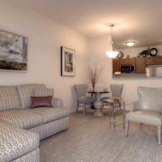 A cozy living room with a patterned sofa, dining table, and subtle interior decor.