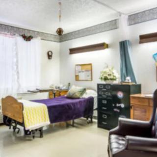 A hospital room with a bed, various furniture, and medical equipment.