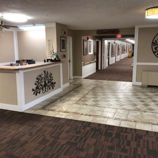 A spacious hotel lobby with a reception desk and a long hallway.