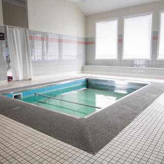 An indoor therapy pool with a tiled floor and natural lighting.