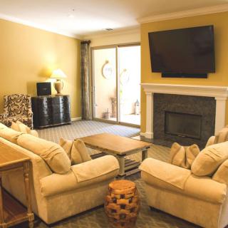 A cozy living room with comfortable seating, a fireplace, and a large television.