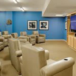 A cozy home theater room with comfortable seating and a big screen.