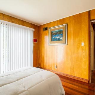 A cozy bedroom with wood paneling and minimalist decor.