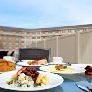 A rooftop breakfast setup with assorted dishes and a scenic view.