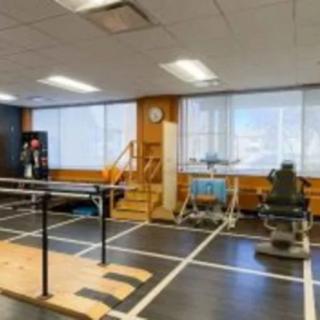 A physical therapy room equipped with various rehabilitation exercise machines and tools.
