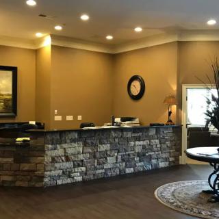 A cozy reception area with a stone-accented desk and warm lighting.