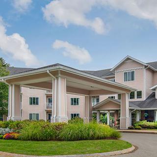 A well-maintained building with a covered entrance and landscaped surroundings.