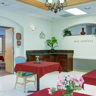 A modern dining area with red tablecloths and decorative plants.