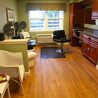 A cozy hair salon interior with stylish seating and equipment.