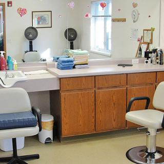 An interior view of a hair salon with barber chairs and mirrors.