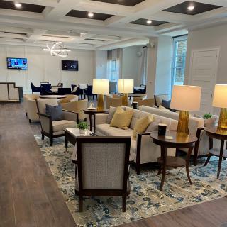 A modern, comfortable lobby area featuring sofas, armchairs, and table lamps.
