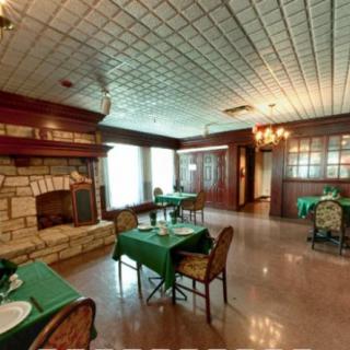 A cozy restaurant interior with a fireplace and elegantly set tables.
